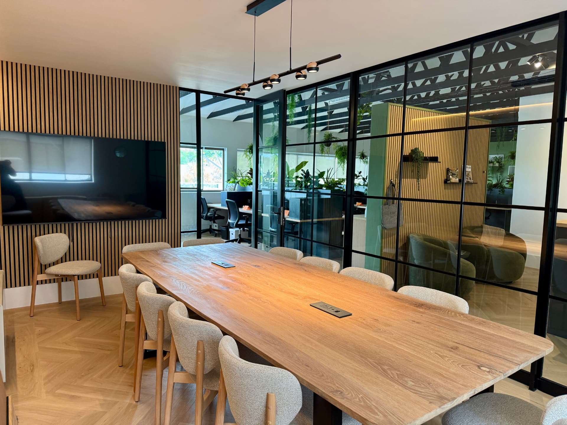 Meeting room framed by black steel and glass partitioning