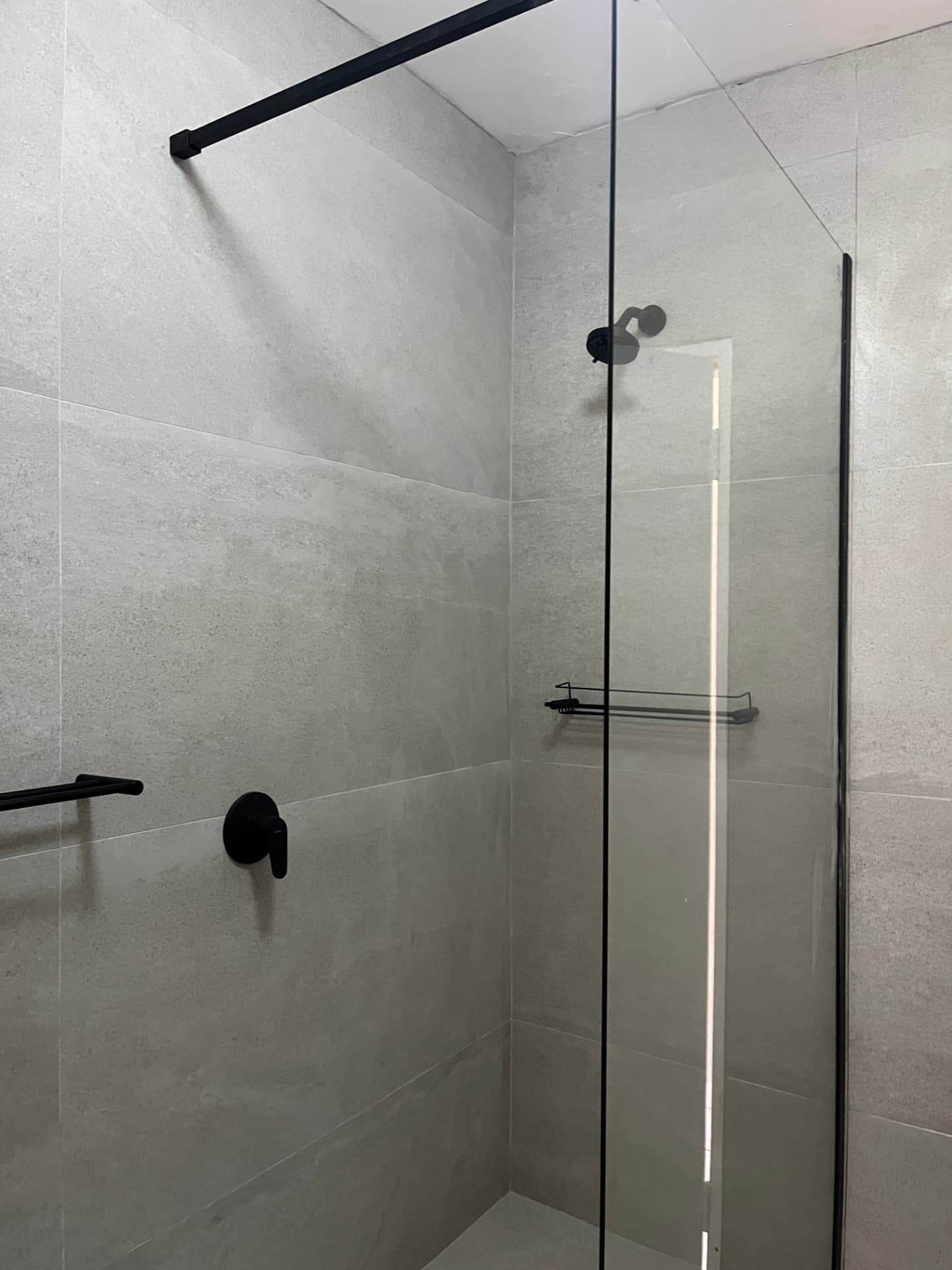 After: walk-in shower with glass screen, matte black rain shower and fittings