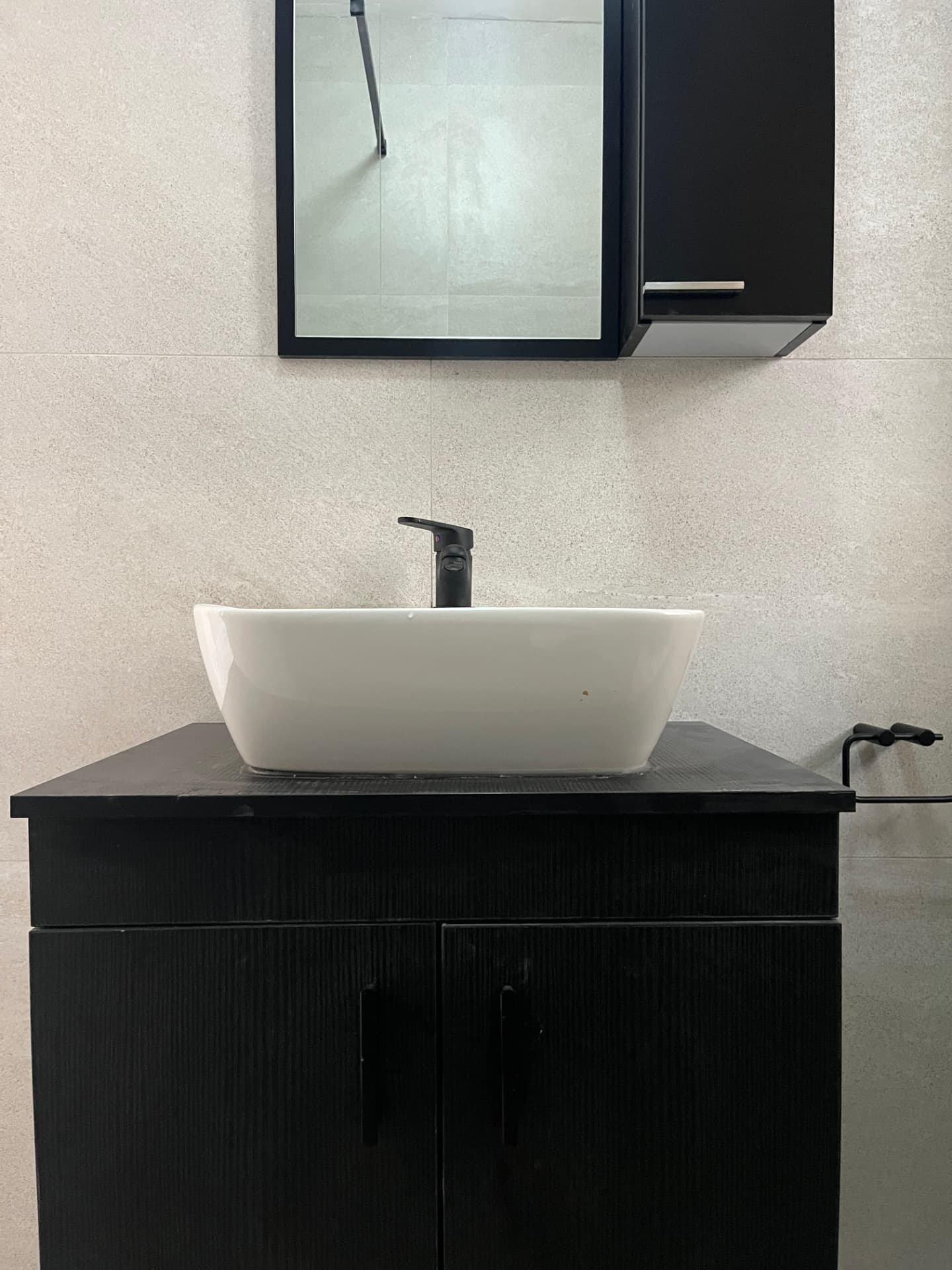 After: vanity with white freestanding basin and matte black mixer on fluted black cabinetry