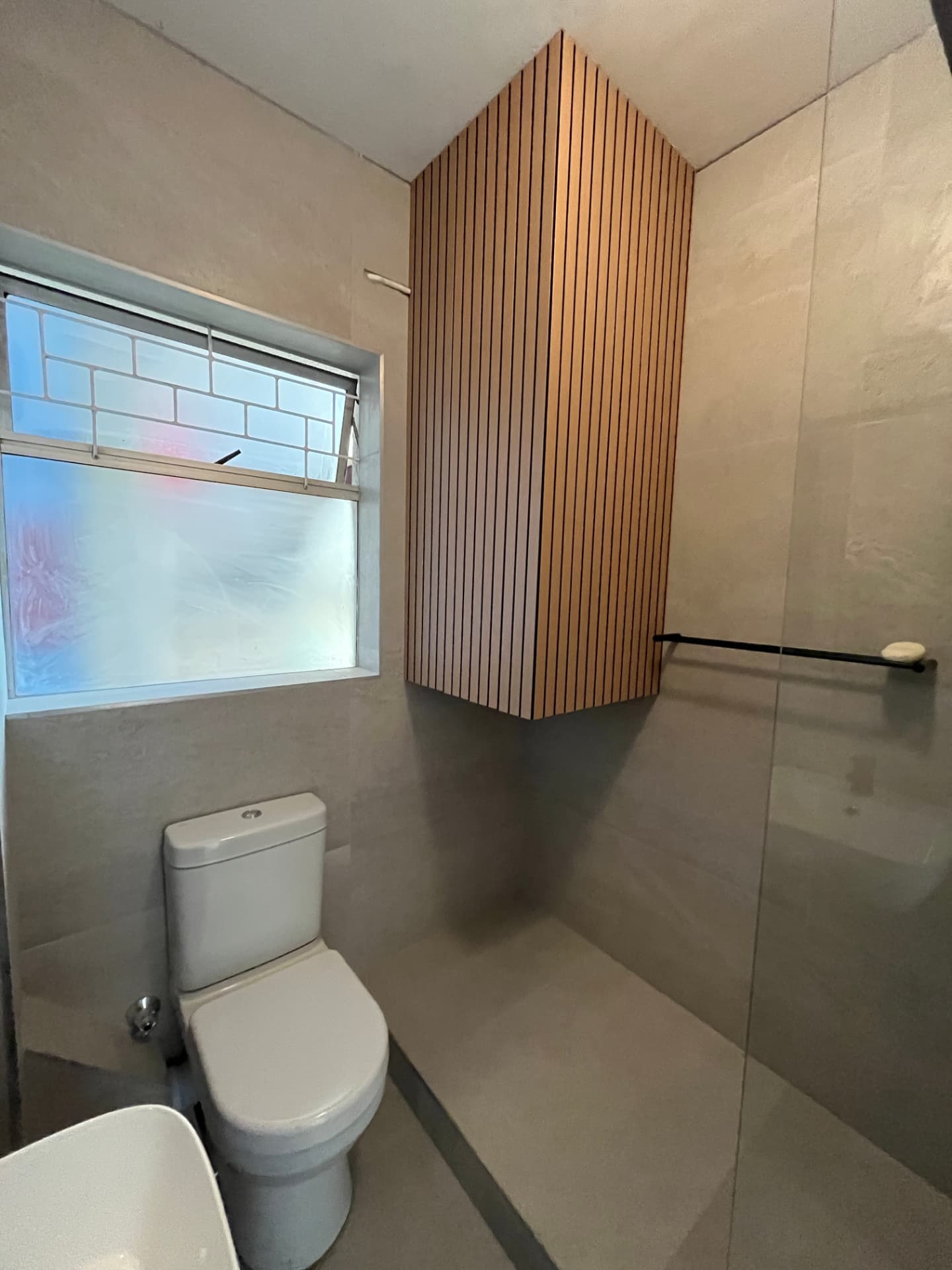 Finished Rosemark bathroom with timber slatted feature panel, toilet and walk-in shower