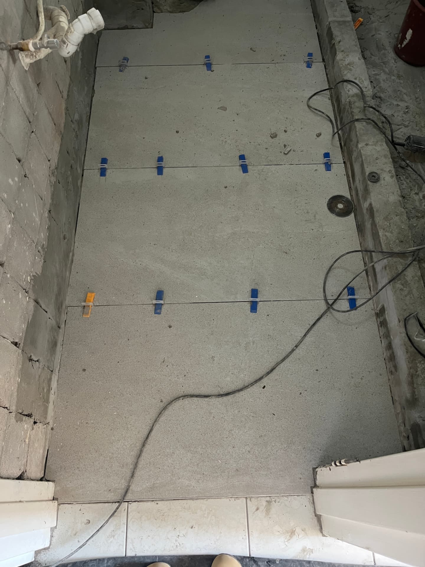 Large-format stone-look floor tiles bedded with levelling clips