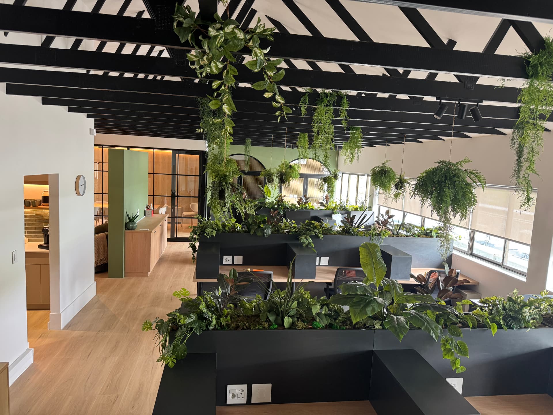 Workstations with planter dividers and layered indoor greenery