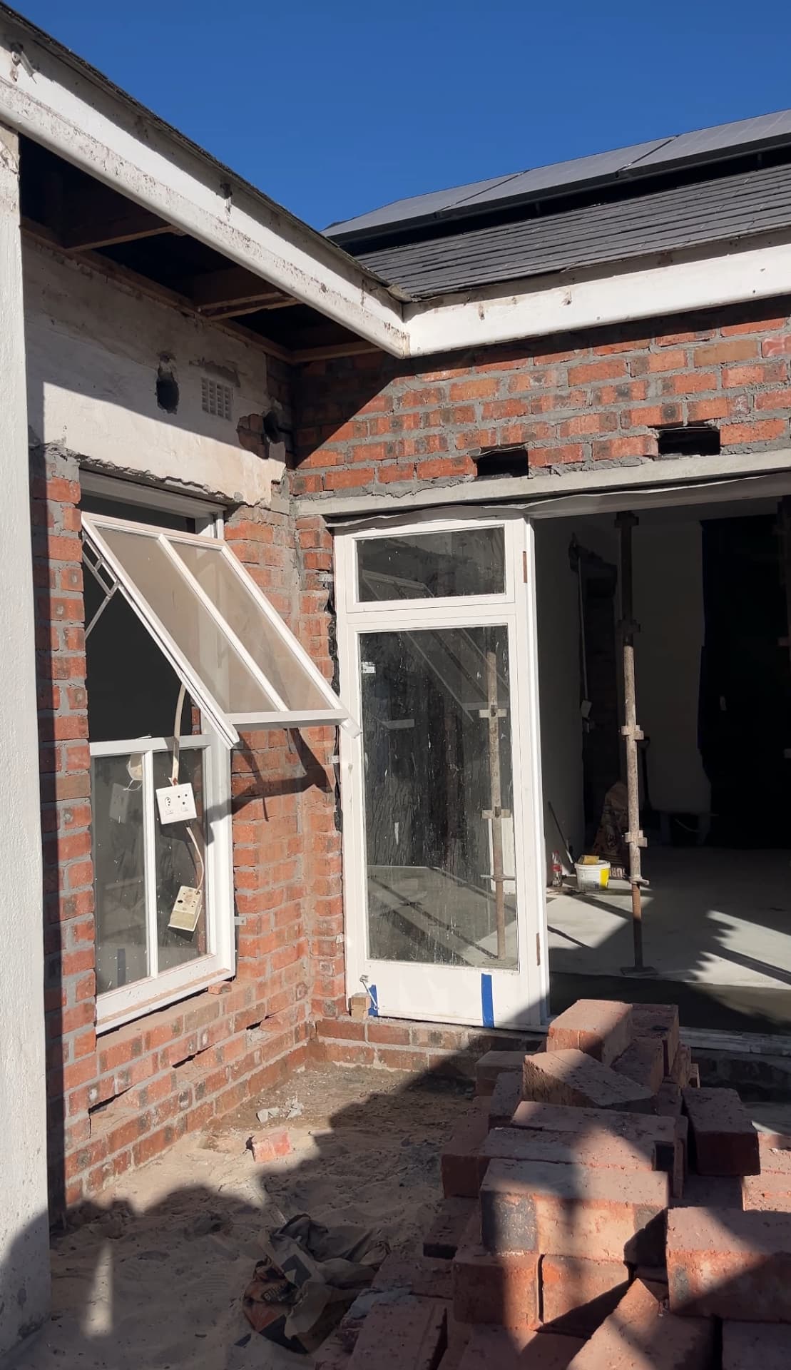 Construction in progress with new openings formed in the original brickwork