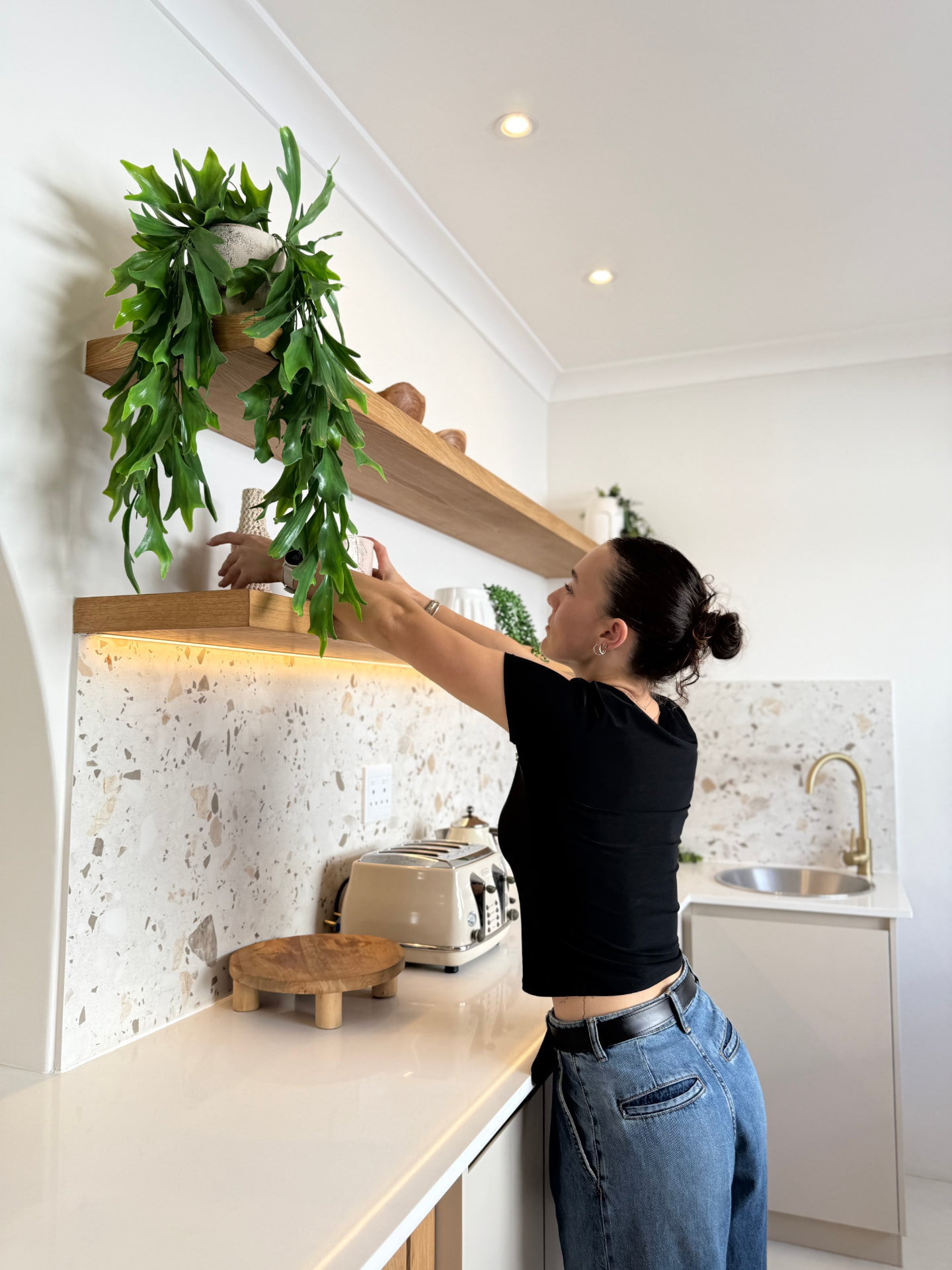 Georgia styling greenery on the oak shelves above the terrazzo splashback