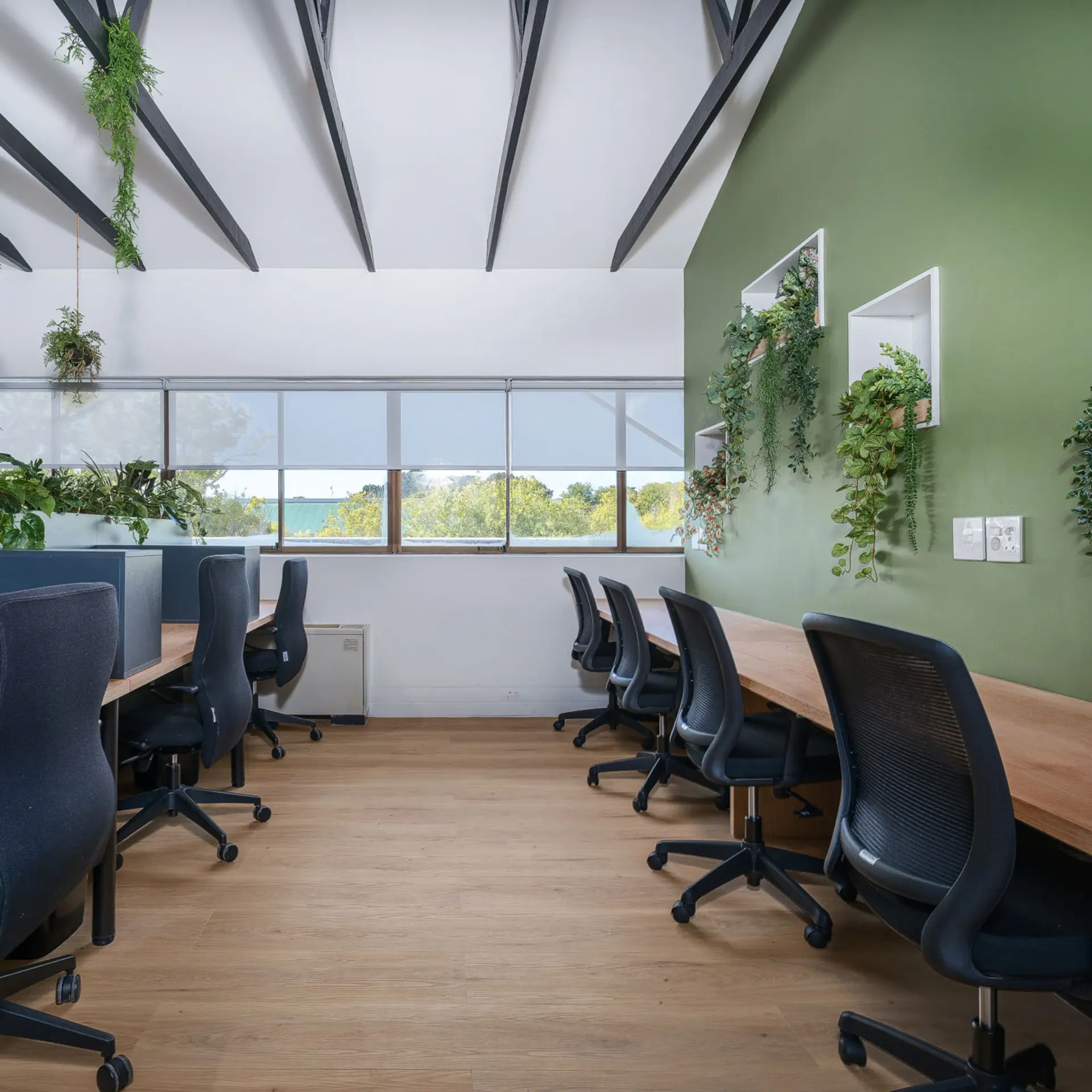 Bench desking along a green feature wall with planted niches