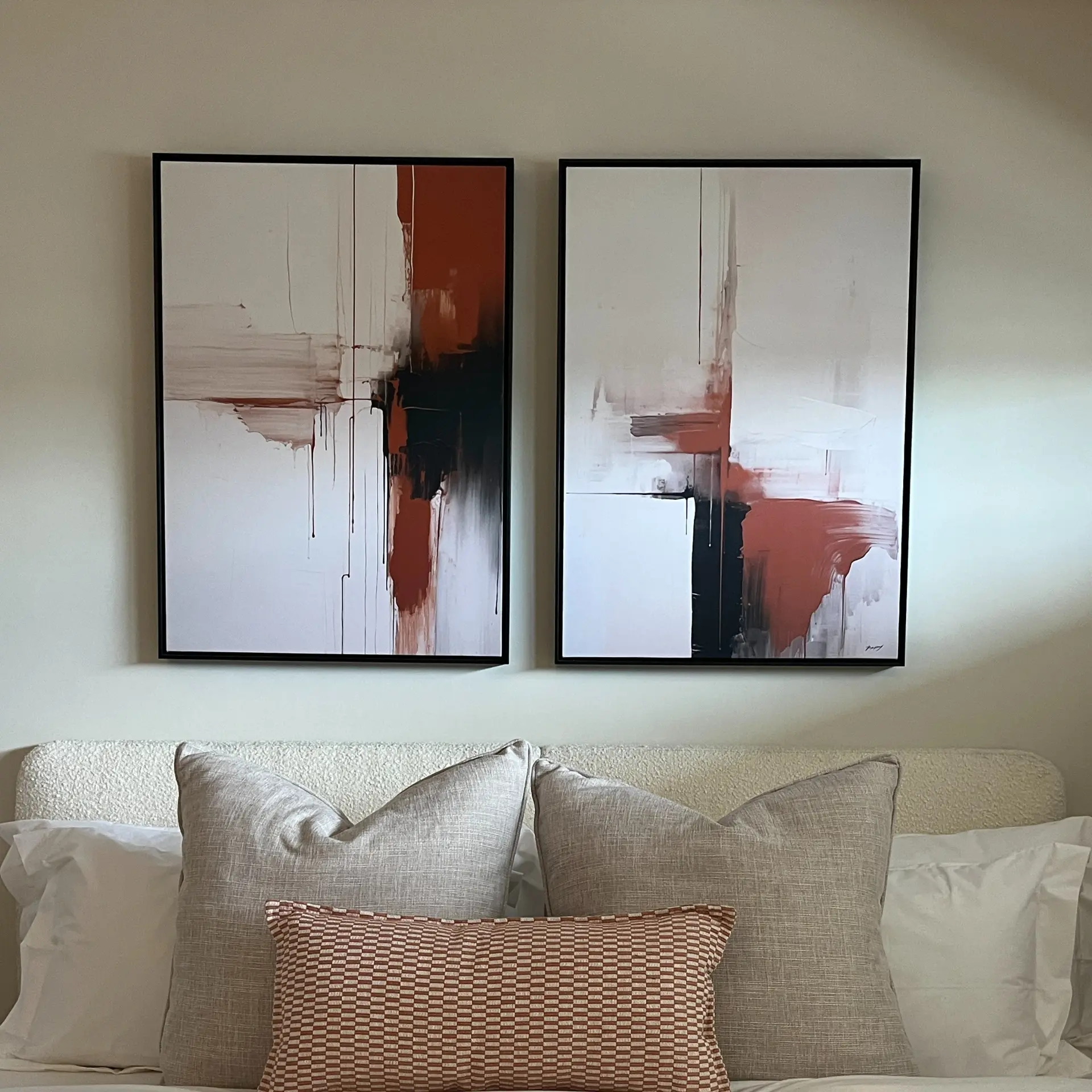 Guest bedroom with terracotta abstract artwork above a bouclé headboard