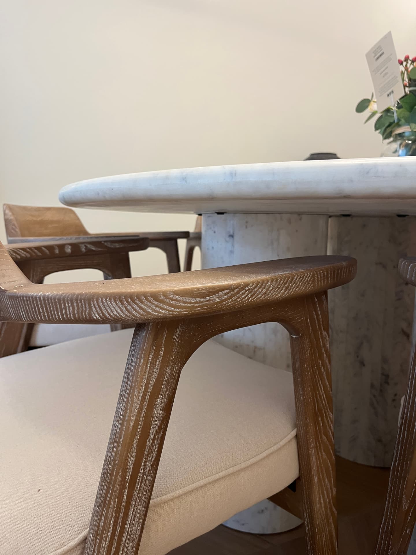 Marble pedestal dining table with sculptural oak chairs